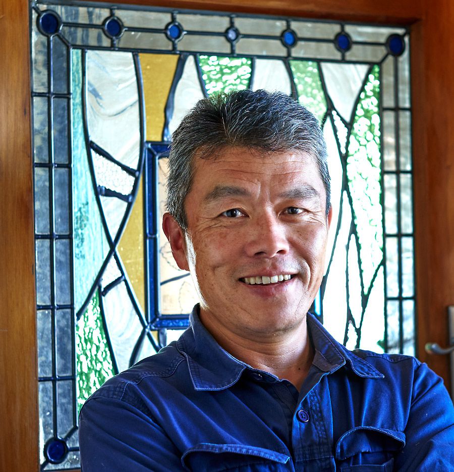 Hiro with his wife Reiko's stained glass window which has become their wine label. Photo : Milton © Wordley