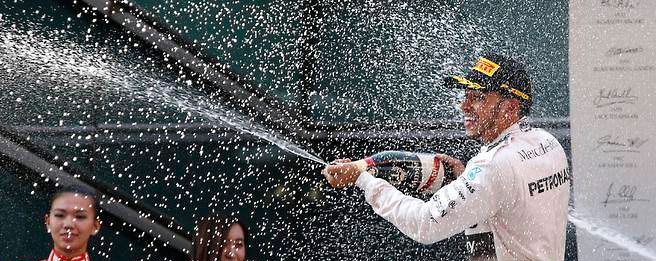 Lewis Hamilton celebrates on the podium after winning the Chinese Grand Prix .